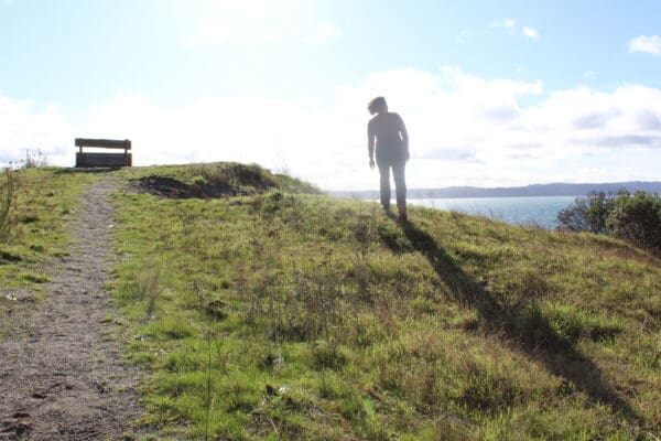 Faded image of woman walking up hill into sunlight